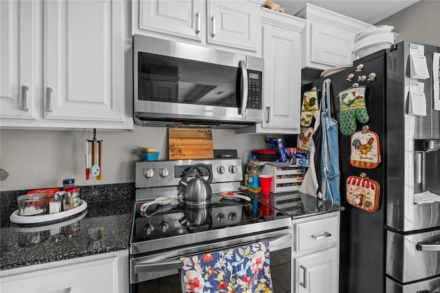 kitchen with dark stone countertops, white cabinetry, and stainless steel appliances