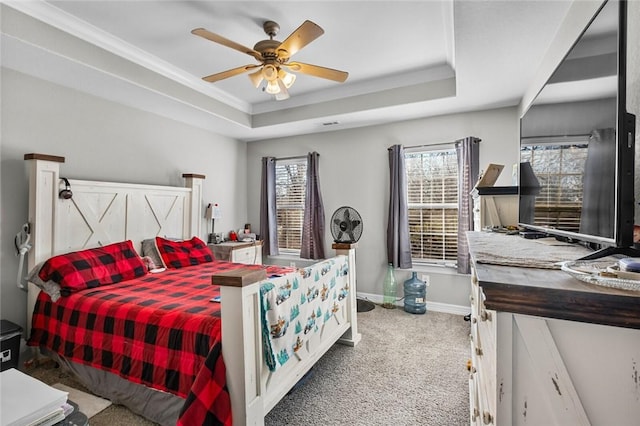 bedroom with carpet flooring, a raised ceiling, and ceiling fan