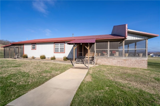 view of front facade with a sunroom, a front lawn, and metal roof