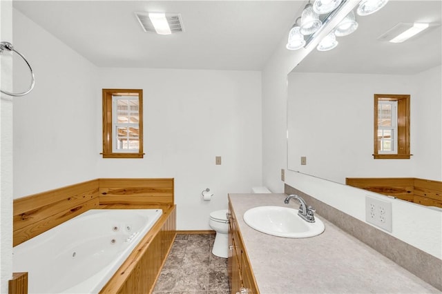 bathroom featuring toilet, vanity, and a bathing tub