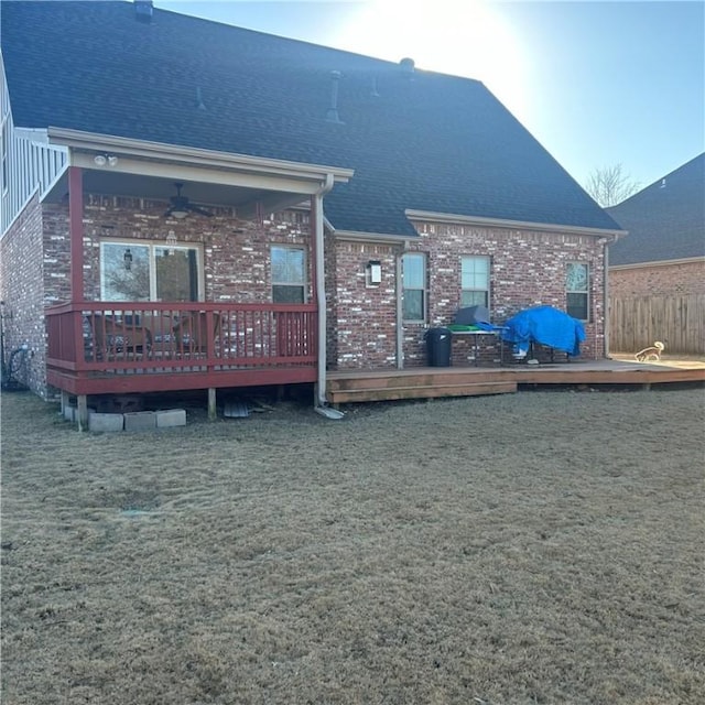 rear view of property with a lawn and a deck