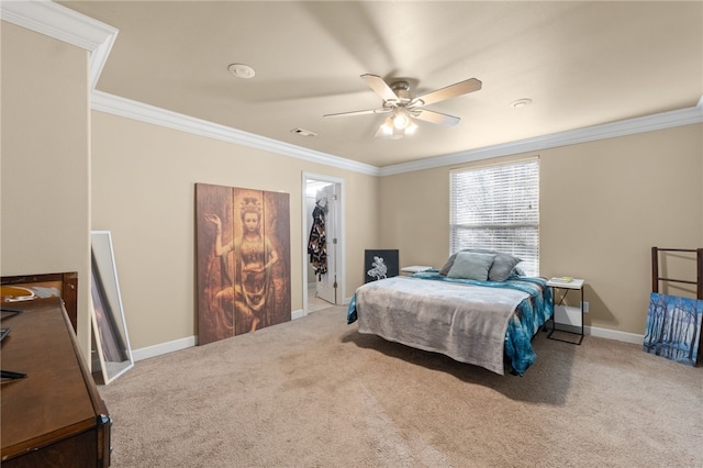 carpeted bedroom with ceiling fan, a spacious closet, crown molding, and a closet