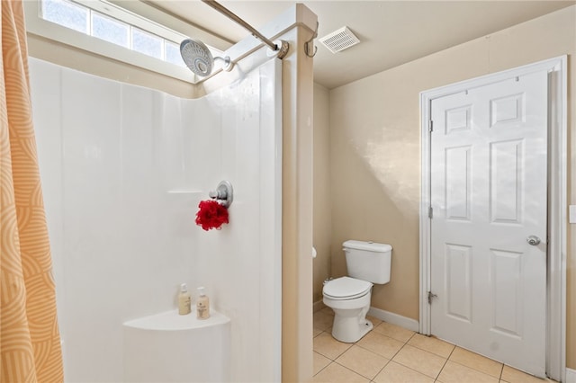 bathroom featuring toilet, tile patterned floors, and walk in shower