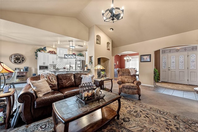 living room featuring arched walkways, light tile patterned floors, lofted ceiling, a notable chandelier, and light carpet