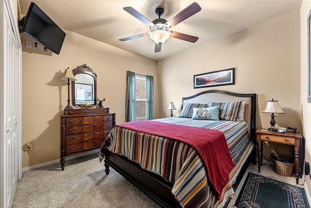 bedroom with light carpet, ceiling fan, baseboards, and a textured ceiling