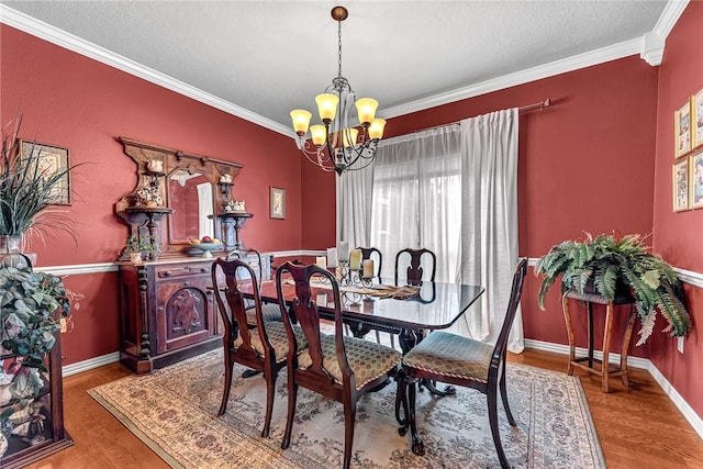 dining area featuring an inviting chandelier, baseboards, ornamental molding, and wood finished floors