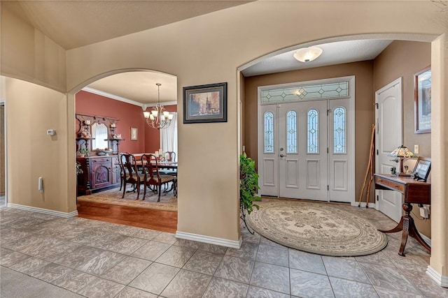 entryway with a wealth of natural light, arched walkways, and baseboards