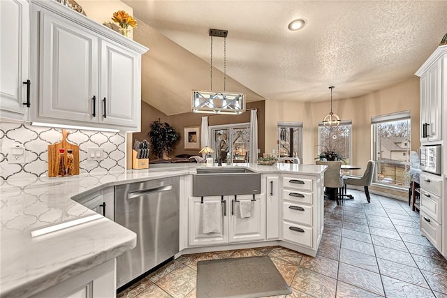 kitchen featuring pendant lighting, appliances with stainless steel finishes, white cabinets, a sink, and a peninsula