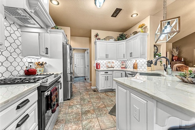 kitchen featuring stainless steel appliances, custom range hood, backsplash, white cabinetry, and a sink