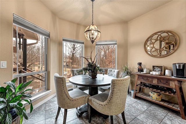 dining area with a chandelier and baseboards