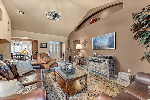 living area featuring high vaulted ceiling, arched walkways, a notable chandelier, and baseboards