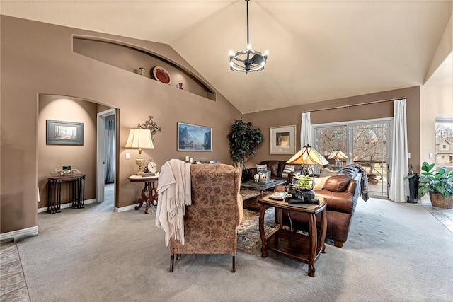 living area with baseboards, carpet floors, high vaulted ceiling, and an inviting chandelier