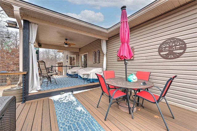 wooden terrace featuring a ceiling fan and outdoor dining space