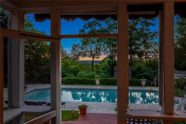 pool at dusk featuring a patio area