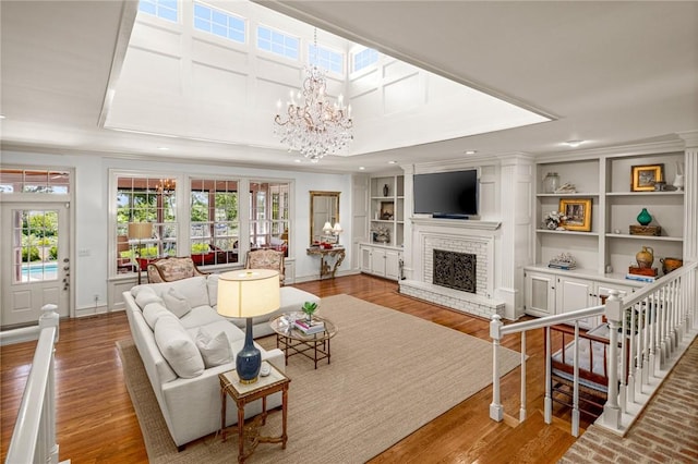 living room with a fireplace, built in features, and a notable chandelier