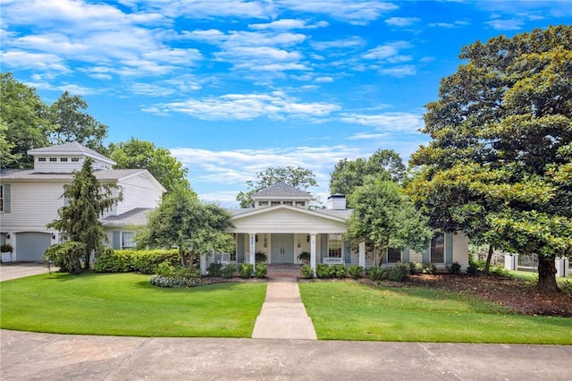 view of front of home featuring a front lawn, a porch, and a garage