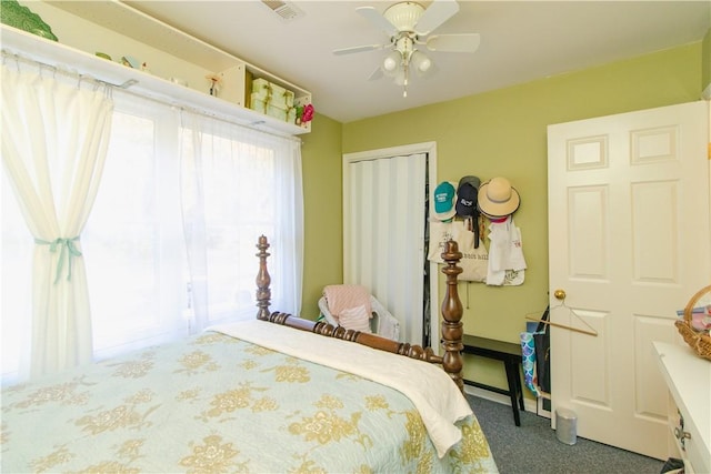 carpeted bedroom featuring ceiling fan and a closet