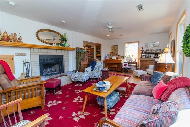 living room with a brick fireplace and ceiling fan