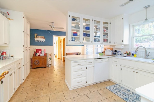 kitchen featuring white dishwasher, white cabinets, ceiling fan, decorative light fixtures, and kitchen peninsula