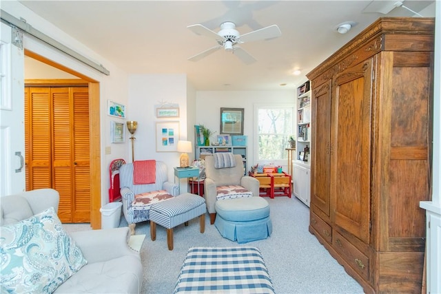 carpeted living room with ceiling fan