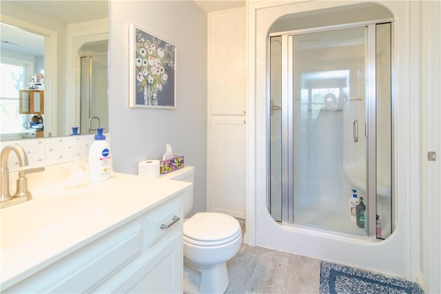 bathroom featuring hardwood / wood-style floors, vanity, toilet, and walk in shower