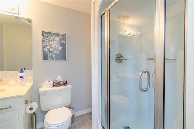 bathroom featuring vanity, toilet, and walk in shower