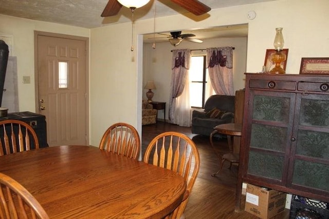 dining area with a textured ceiling, ceiling fan, and dark wood-type flooring