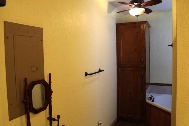 bathroom with ceiling fan and a tub