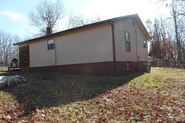 view of side of property featuring a lawn and cooling unit