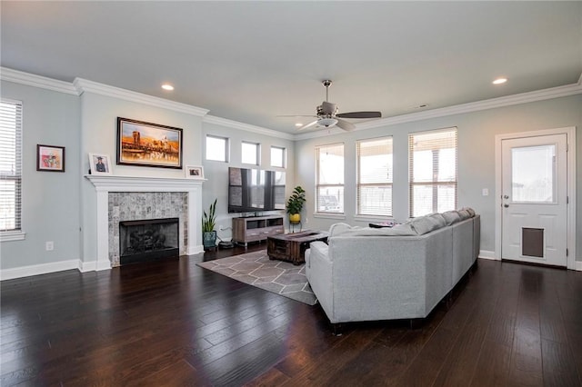 living room with dark hardwood / wood-style flooring, a fireplace, ceiling fan, and ornamental molding