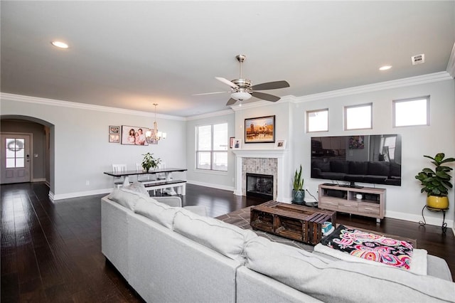 living room featuring crown molding, dark hardwood / wood-style floors, and a fireplace