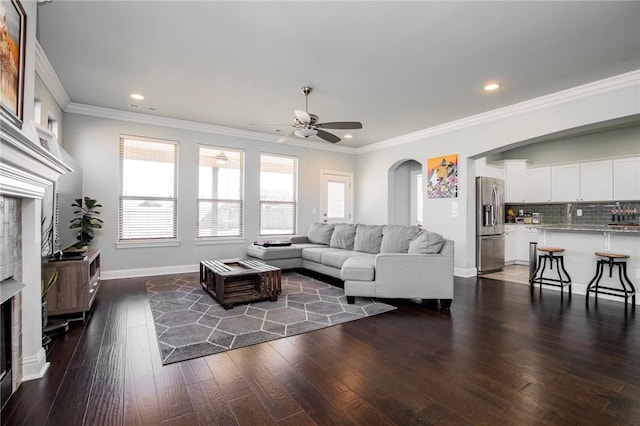 living room with dark hardwood / wood-style flooring, ornamental molding, and plenty of natural light