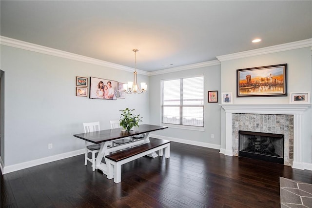 dining room with a fireplace, a chandelier, crown molding, and dark wood-type flooring