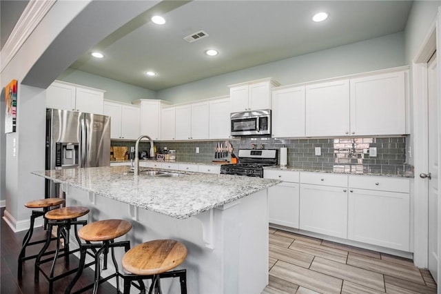 kitchen with stainless steel appliances, white cabinets, and sink