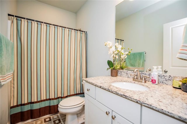 bathroom with toilet, walk in shower, and vanity