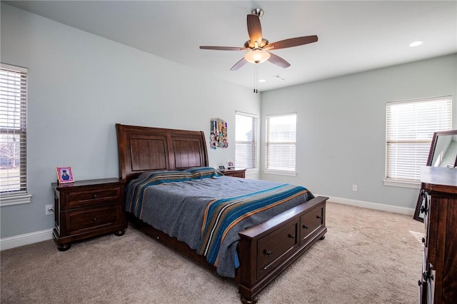 bedroom featuring multiple windows, light carpet, and ceiling fan