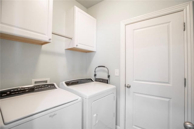 washroom featuring separate washer and dryer and cabinets