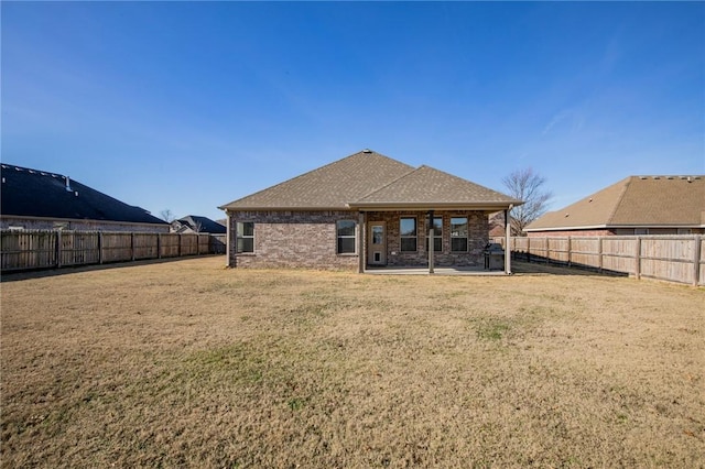 rear view of house featuring a patio area and a lawn