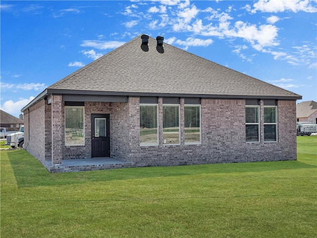 rear view of house featuring a lawn