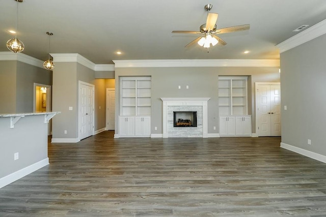 unfurnished living room featuring dark hardwood / wood-style floors, built in features, ceiling fan, and crown molding