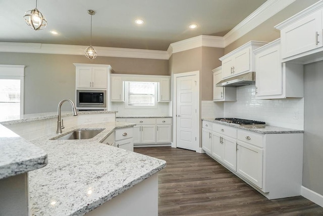 kitchen featuring white cabinets, built in microwave, hanging light fixtures, and sink