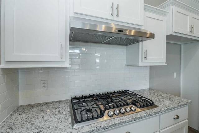 kitchen featuring backsplash, light stone countertops, white cabinets, and stainless steel gas cooktop