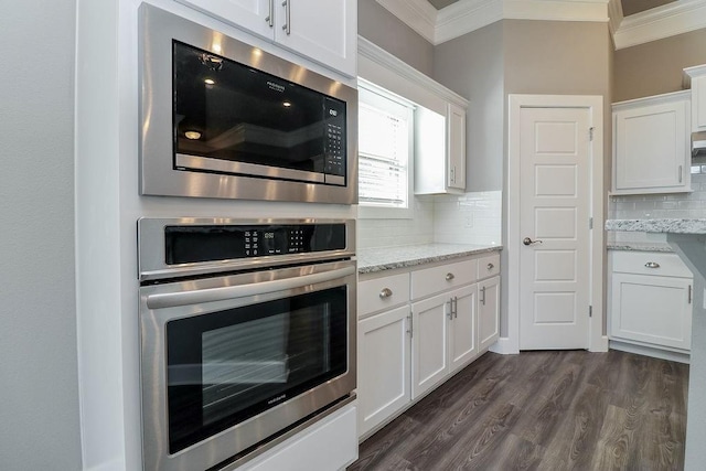 kitchen featuring light stone counters, white cabinetry, appliances with stainless steel finishes, and tasteful backsplash