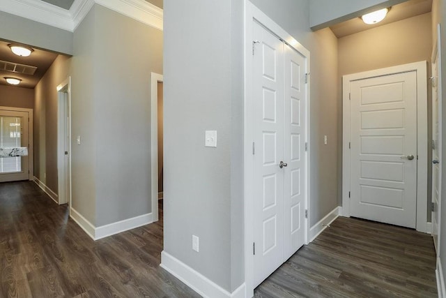 hallway with dark wood-type flooring and ornamental molding