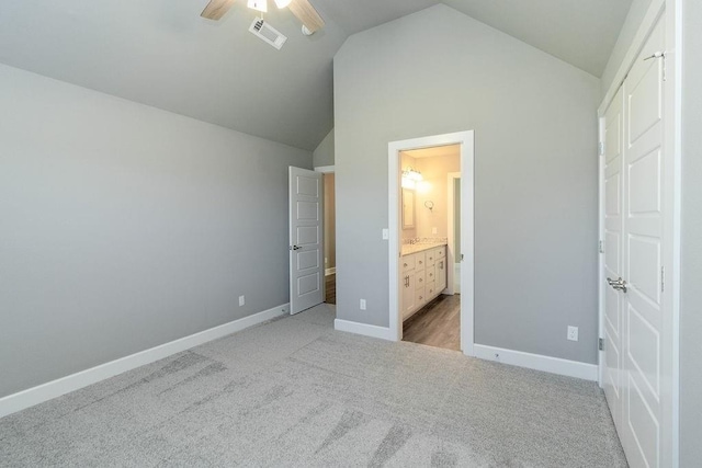 unfurnished bedroom featuring ceiling fan, light colored carpet, ensuite bathroom, and high vaulted ceiling