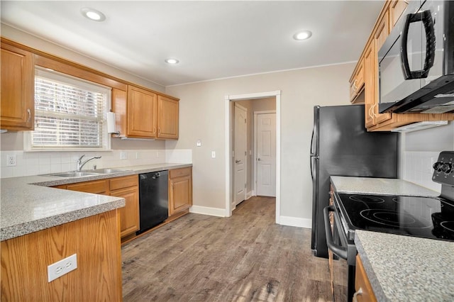 kitchen featuring stainless steel electric range oven, a sink, light wood-style floors, dishwashing machine, and black microwave
