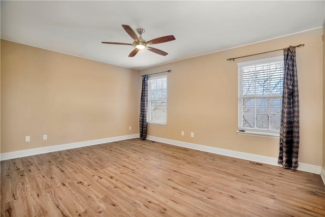 unfurnished room featuring baseboards, light wood-type flooring, and a ceiling fan
