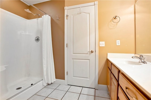 full bath featuring a stall shower, tile patterned floors, baseboards, and vanity