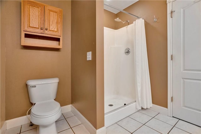 bathroom with tile patterned flooring, toilet, and a stall shower