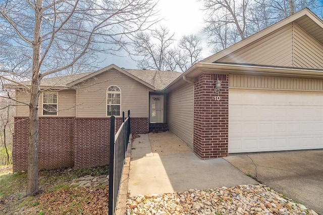view of front of property featuring brick siding, concrete driveway, and an attached garage